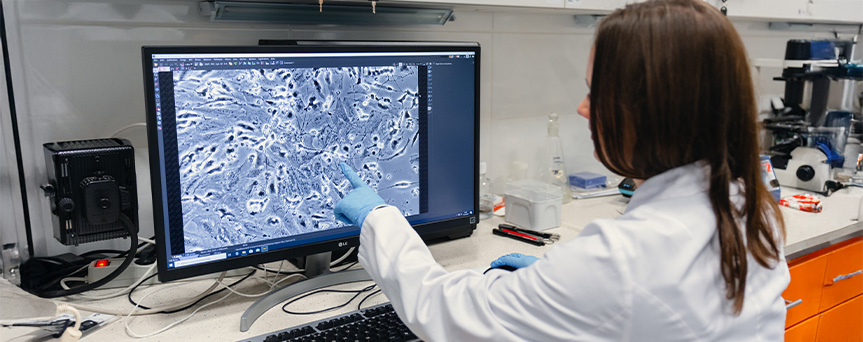 Badacz wskazuje na monitor komputer na obiekty, które bada